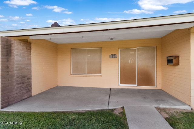 entrance to property with a patio area and brick siding