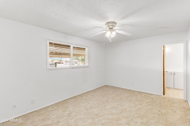 empty room with baseboards, a ceiling fan, and a textured ceiling