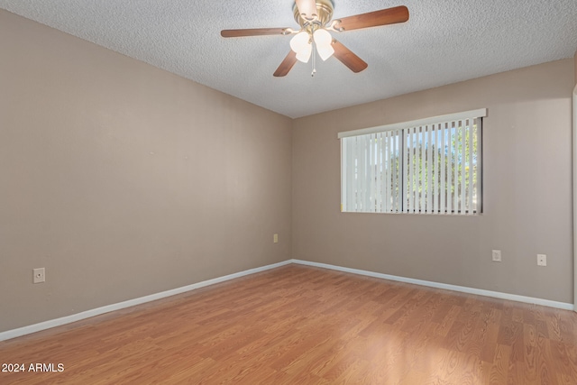 spare room featuring a textured ceiling, light hardwood / wood-style flooring, and ceiling fan