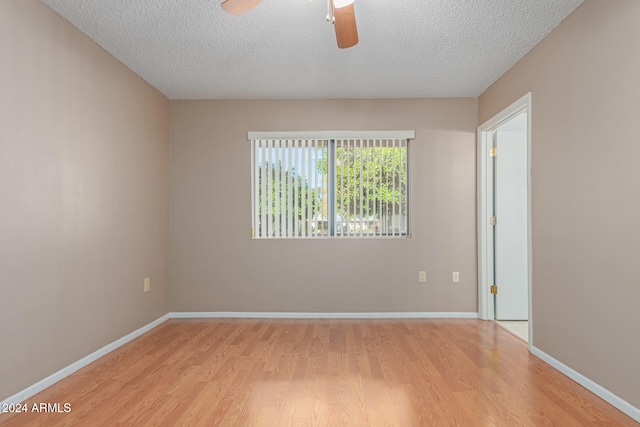 spare room featuring ceiling fan, light hardwood / wood-style flooring, and a textured ceiling