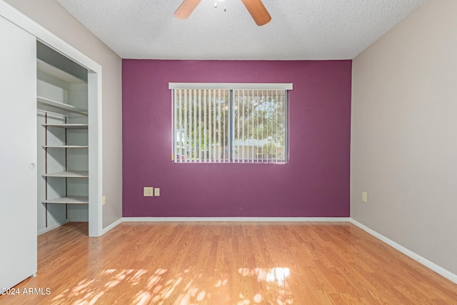 spare room featuring ceiling fan, a textured ceiling, and light hardwood / wood-style flooring