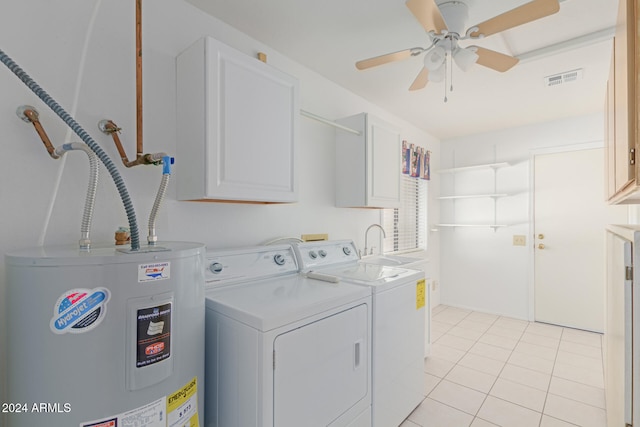 washroom with cabinets, electric water heater, ceiling fan, light tile patterned floors, and washing machine and clothes dryer