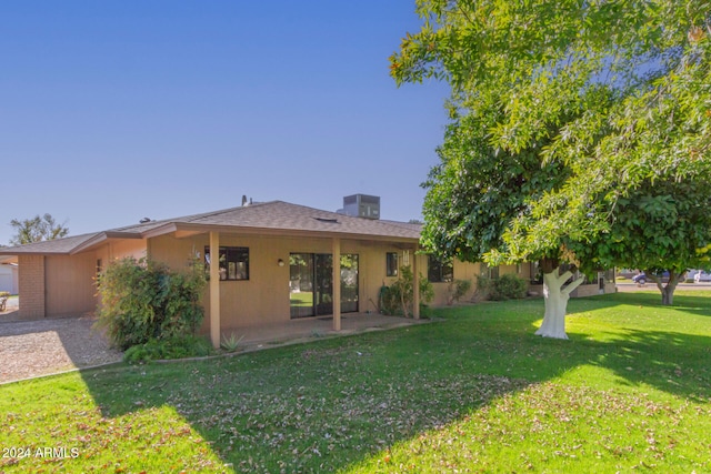 back of house featuring a lawn and a patio