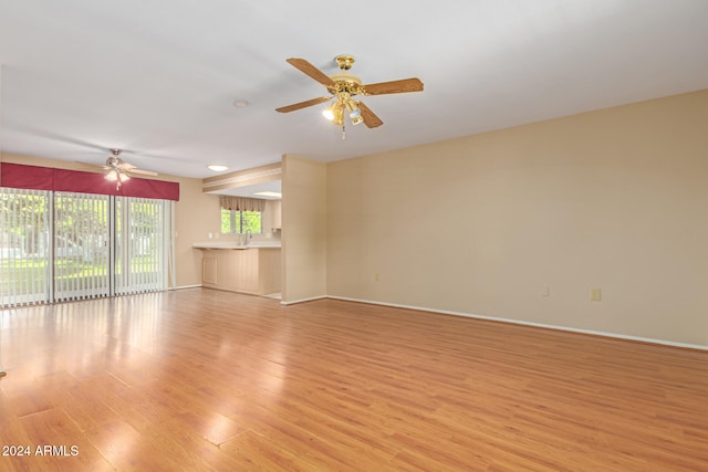 unfurnished living room with light wood-type flooring and ceiling fan