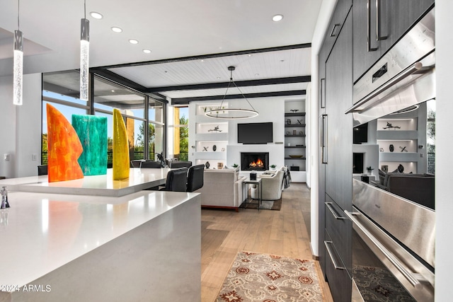 kitchen featuring an inviting chandelier, light wood-type flooring, decorative light fixtures, and expansive windows