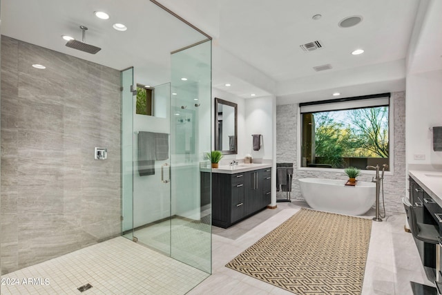 bathroom with plus walk in shower, tile walls, tile patterned floors, and vanity