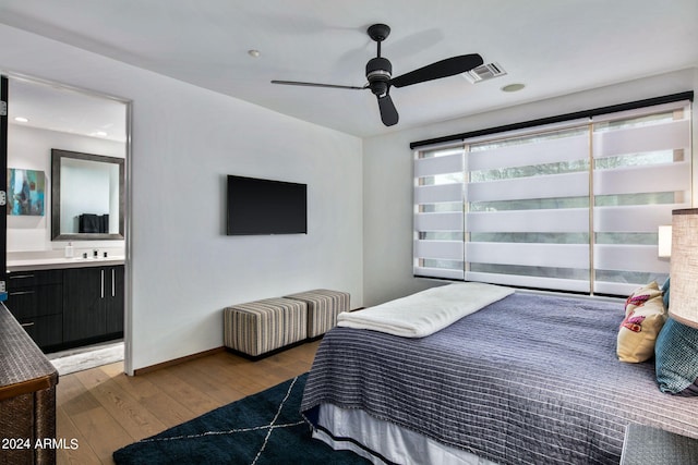 bedroom featuring wood-type flooring, radiator heating unit, ensuite bath, and ceiling fan