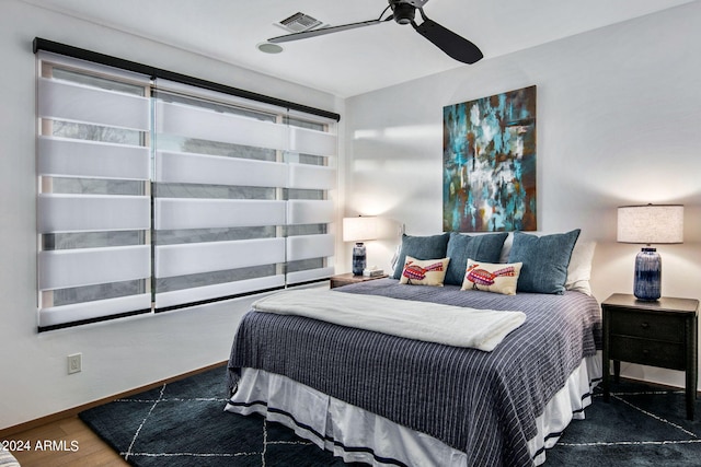 bedroom with dark hardwood / wood-style flooring and ceiling fan