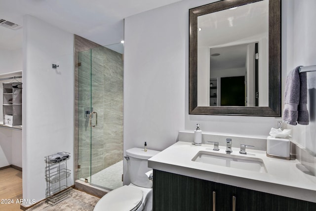 bathroom with vanity, hardwood / wood-style floors, toilet, and a shower with door