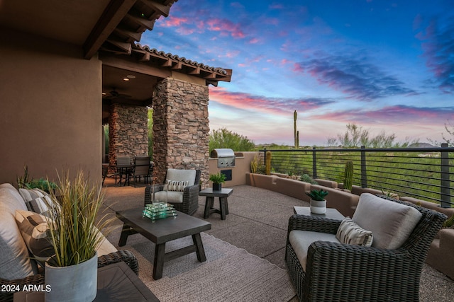 patio terrace at dusk with outdoor lounge area, area for grilling, and a balcony