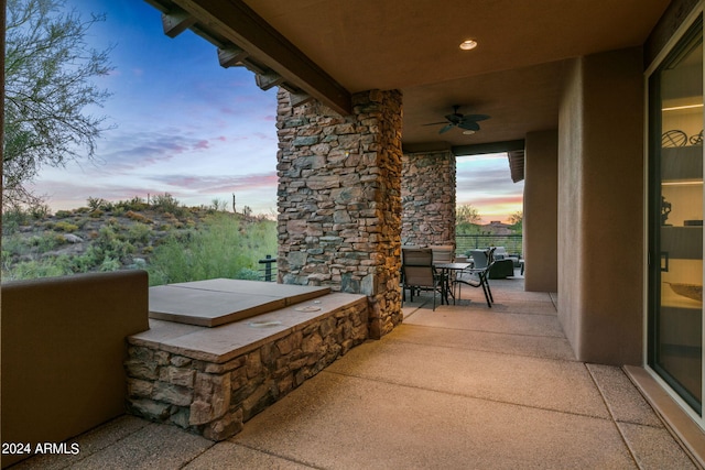 patio terrace at dusk featuring ceiling fan