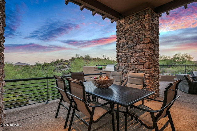 patio terrace at dusk featuring a balcony