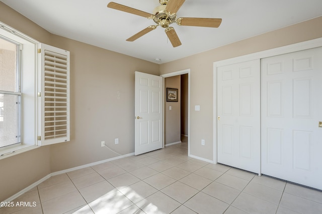 unfurnished bedroom featuring light tile patterned floors, a closet, and ceiling fan