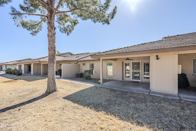 rear view of property featuring ceiling fan, central AC unit, and a patio area