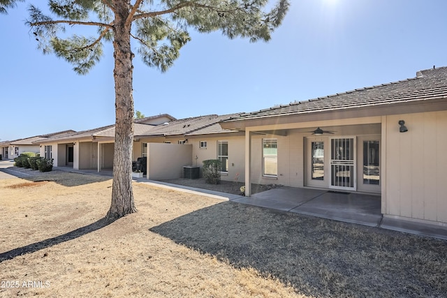 rear view of property with a patio area, ceiling fan, central air condition unit, and a garage