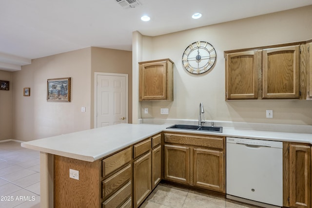 kitchen with white dishwasher, kitchen peninsula, sink, and light tile patterned floors