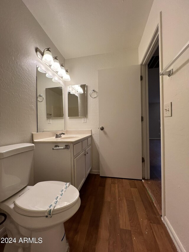 bathroom with vanity, toilet, and hardwood / wood-style floors