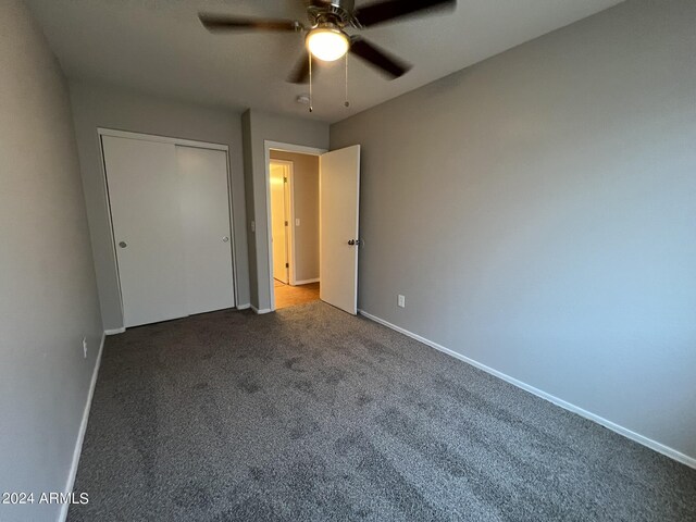 unfurnished bedroom with carpet floors, ceiling fan, and a closet