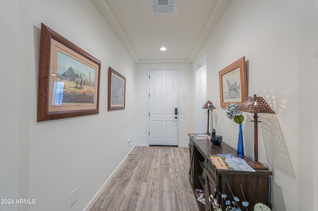 doorway to outside featuring crown molding and light hardwood / wood-style flooring