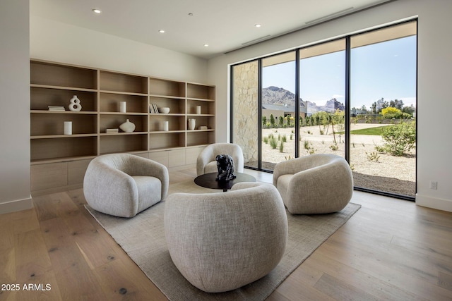 living area with a mountain view, baseboards, recessed lighting, and wood finished floors