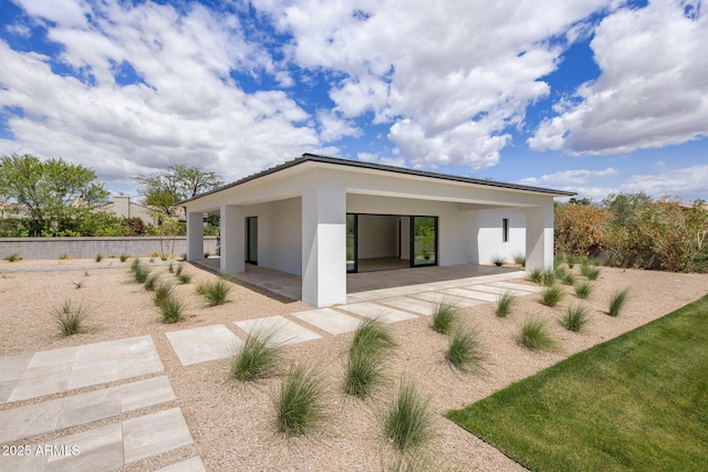 back of house with a patio, stucco siding, and fence