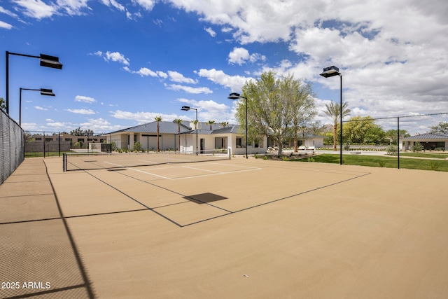 view of home's community featuring a tennis court and fence