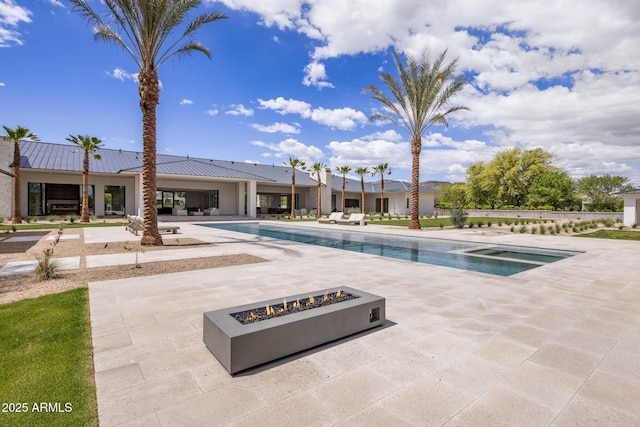 view of swimming pool with a fenced in pool, a patio, and an outdoor fire pit