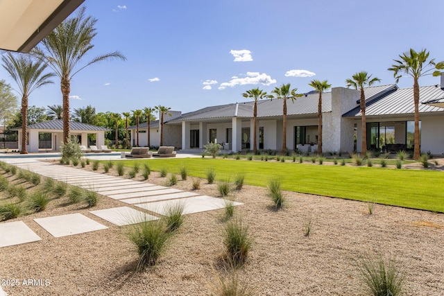 rear view of house featuring a patio, an outdoor pool, a yard, and metal roof