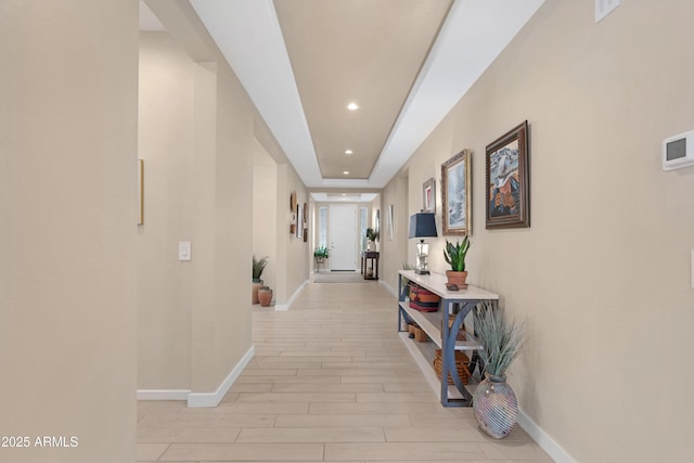 hall featuring recessed lighting, baseboards, and light wood-type flooring