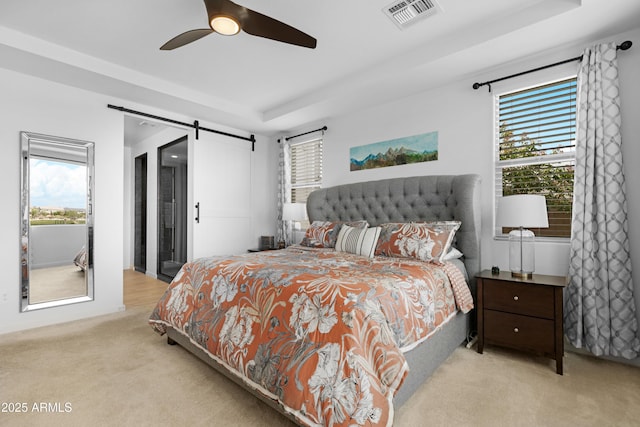 bedroom featuring visible vents, a barn door, ceiling fan, and carpet floors