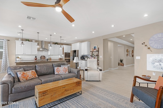 living area with light wood-type flooring, recessed lighting, baseboards, ceiling fan, and visible vents