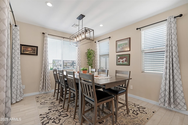 dining space with a wealth of natural light, a notable chandelier, visible vents, and recessed lighting