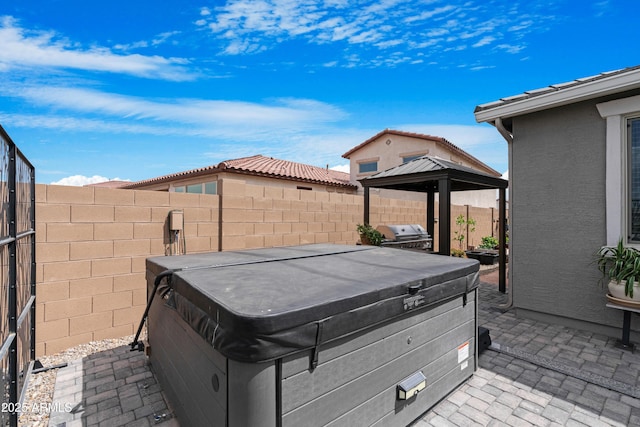 view of patio / terrace with a fenced backyard, a gazebo, and a hot tub
