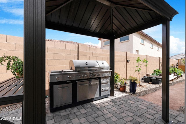 view of patio / terrace featuring a garden, area for grilling, a gazebo, and fence