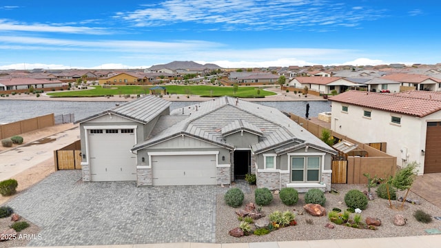 view of front facade with a residential view, driveway, and fence