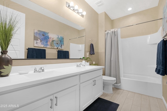 bathroom featuring double vanity, visible vents, toilet, and a sink