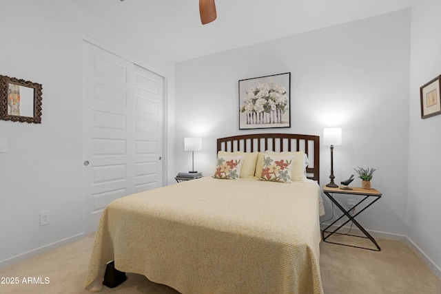 bedroom with baseboards, a closet, a ceiling fan, and light carpet