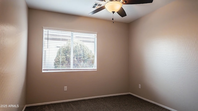 spare room featuring ceiling fan and dark colored carpet