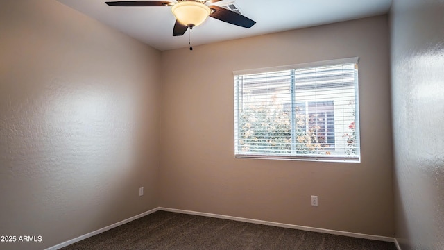 carpeted spare room featuring plenty of natural light and ceiling fan