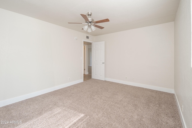 carpeted spare room with ceiling fan