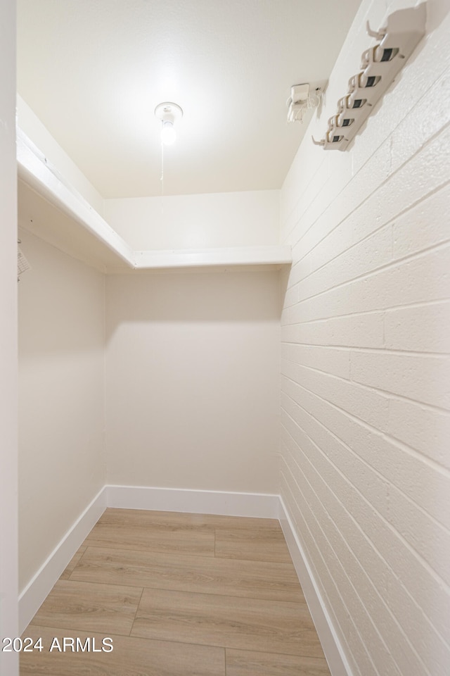 walk in closet with light wood-type flooring