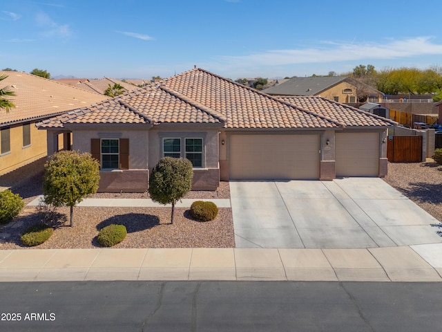 view of front facade with stucco siding, a tiled roof, an attached garage, and concrete driveway