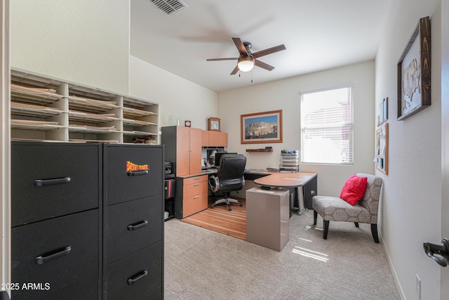 office with light carpet, visible vents, ceiling fan, and baseboards