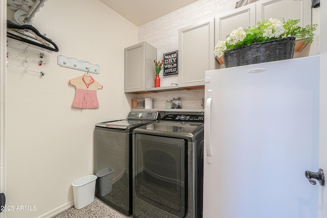 washroom featuring cabinet space, washer and dryer, and baseboards