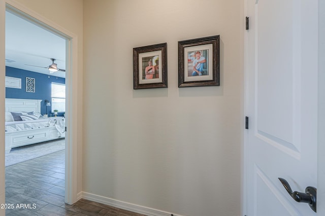 hall featuring baseboards and wood finished floors