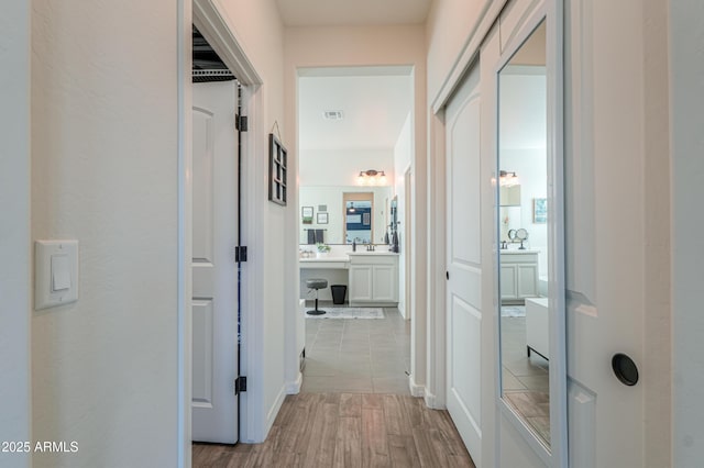 hall featuring visible vents and light wood finished floors