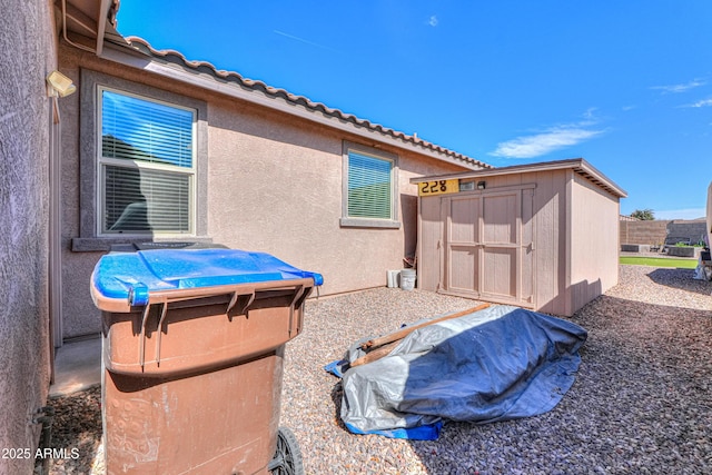 exterior space featuring a storage unit, an outdoor structure, and fence