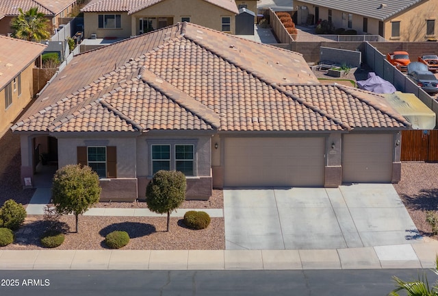 view of front facade featuring stucco siding, fence, an attached garage, and a tile roof