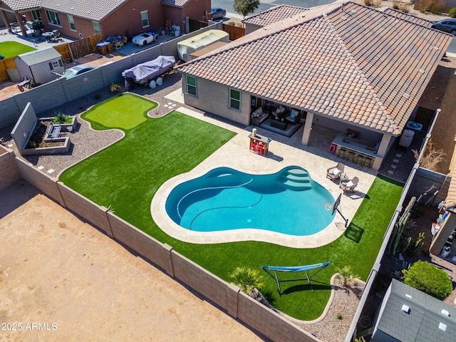 view of pool with a patio area, a fenced backyard, and outdoor dry bar