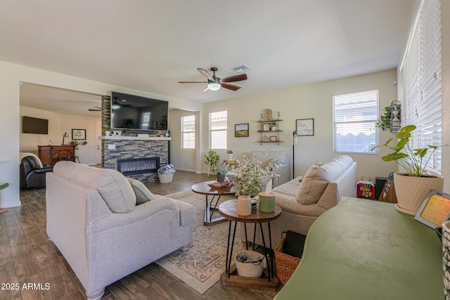 living area featuring a fireplace, wood finished floors, a healthy amount of sunlight, and visible vents